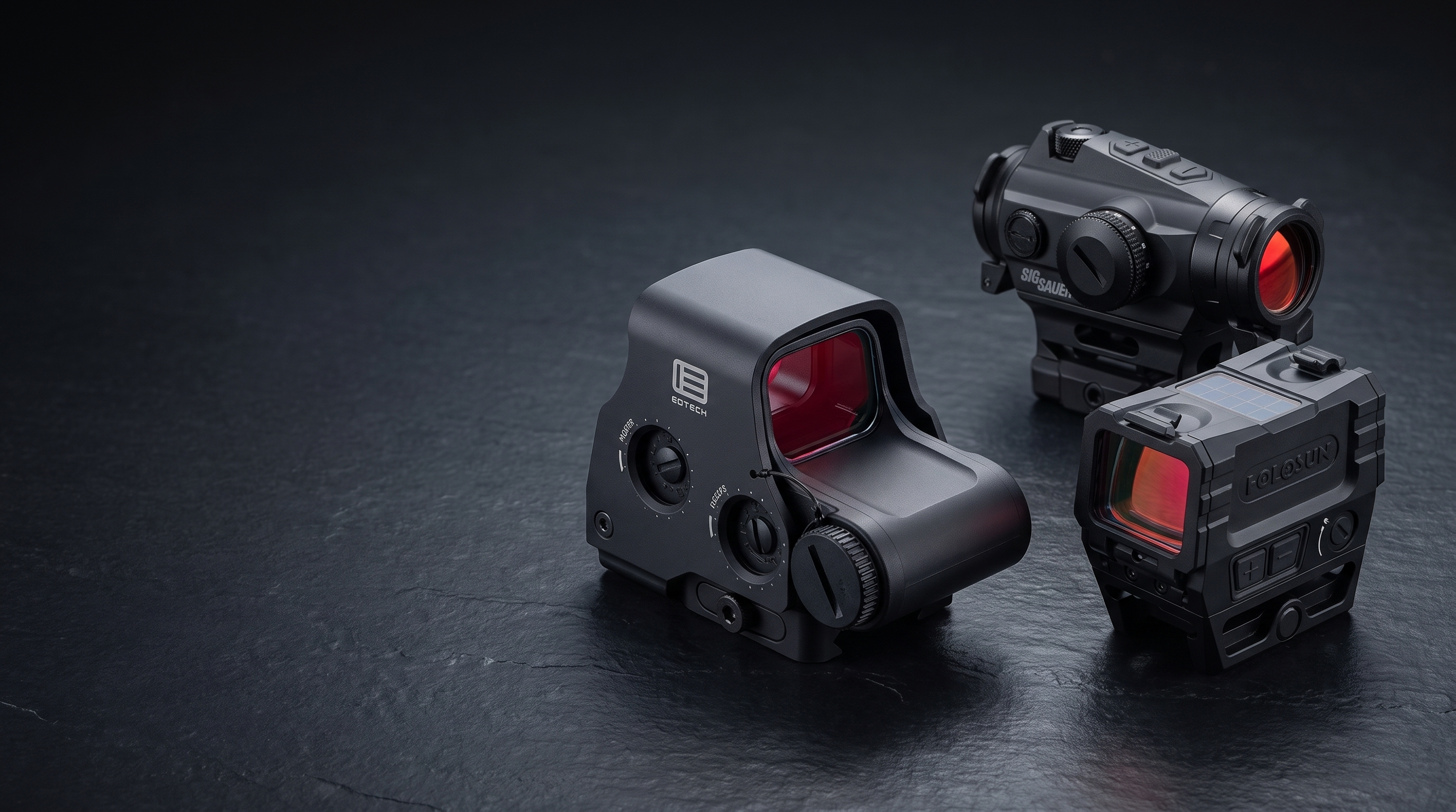 Premium red dot sights and a holographic weapon sight arranged on dark polished slate